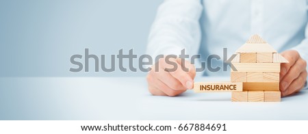Property (family house) insurance protection concept. Insurance agent complete wooden model of the house with last piece with text insurance. Royalty-Free Stock Photo #667884691