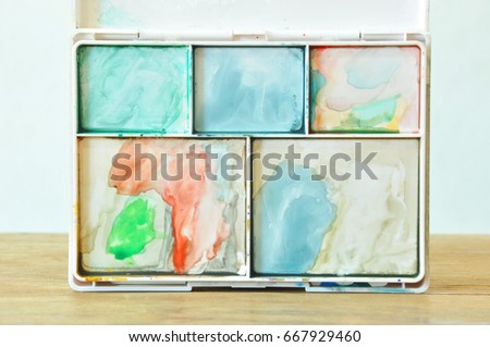 Watercolor tray with water stains attached.