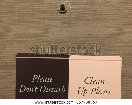 hotel do not disturb and Clean up pleas magnet cards hanging signs on the wooden door background