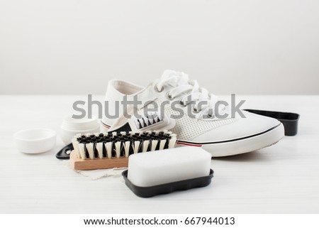 Care for leather shoes over white wooden background. The background image place for text. Royalty-Free Stock Photo #667944013