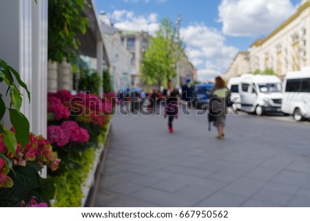 The image is blurry for the abstract background and can be an illustration to an article of cars traveling down the street on a sunny day
