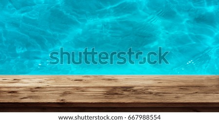 Swimming pool with clear blue water and a wooden edge for a leisure concept