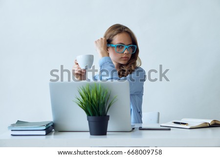Young woman with glasses at the desk, laptop, office, coffee, busy.