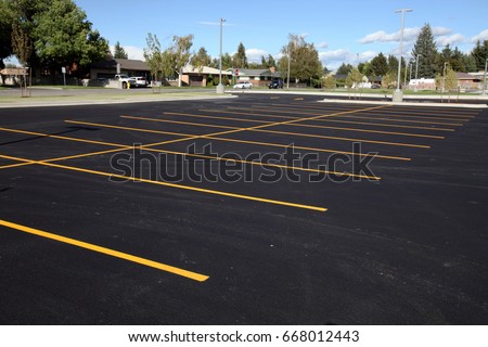 A newly completed parking lot with freshly painted yellow lines to mark the stalls. Royalty-Free Stock Photo #668012443
