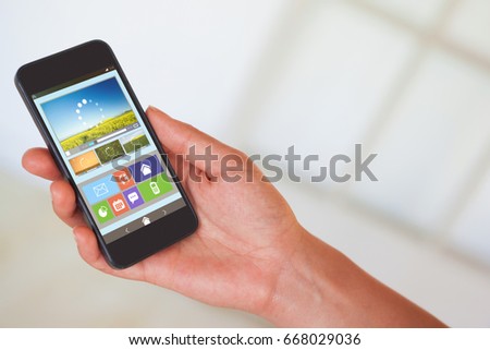 Womans hand holding black smartphone against vector image of various video and icons