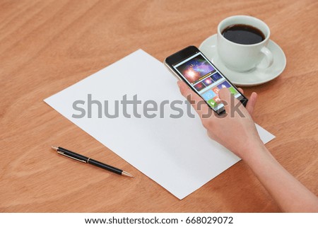 Digitally generated image of device screen against hands using mobile phone
