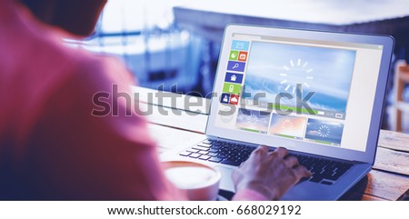 Illustration of various video and computer icons against woman using laptop in cafe
