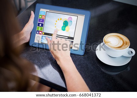 Composite image of various video and computer icons against woman having coffee and using her tablet