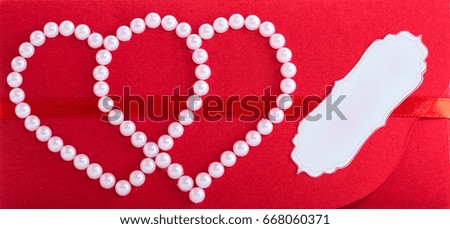red greeting pattern decorated with two hearts and white pearl beads 