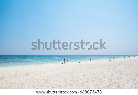 Beautiful famous white long sand beach with tourist enjoying the sunlight and beautiful blue sea water.