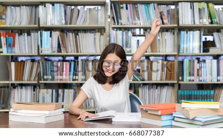 Student asian girl study with glasses finish hard reading book homework and happy learning feeling relax in classroom lesson education library knowledge center college high school university.  Royalty-Free Stock Photo #668077387