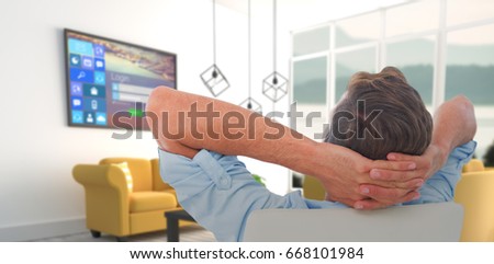 Rear view of male relaxing on chair against yellow sofas in modern living room