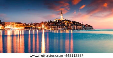 Impressive spring sunset in Rovinj town, Croatian fishing port on the west coast of the Istrian peninsula. Colorful evening seascape of Adriatic Sea. Traveling concept background.