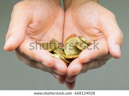 Beautiful of many gold coins in hand close up