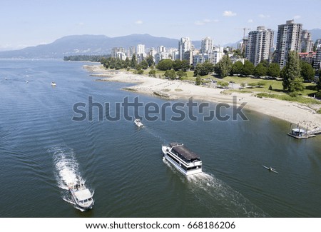 The view of busy False Creek water traffic and Sunset Beach park with Vancouver downtown skyline in a background (British Columbia). 