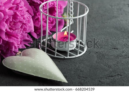 Postcard with heart, peony flowers, candle on black background