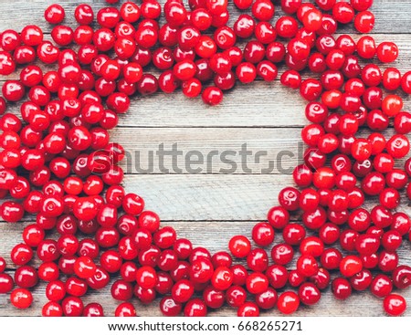heart symbol made of cherry berries on wooden background, top view with space for text. mock up for text, phrases, congratulations, lettering