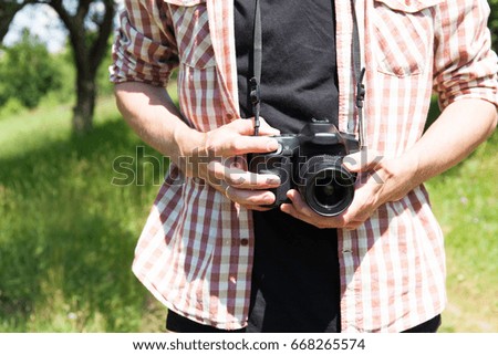 Man photograph with camera in hand on nature