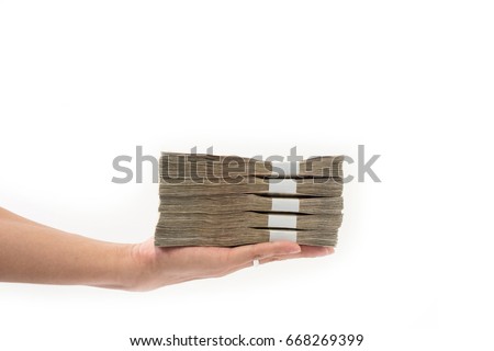 Hand holding stack of many Thai money, Hand giving Thai money on white background, Use for money or financial concept. Royalty-Free Stock Photo #668269399
