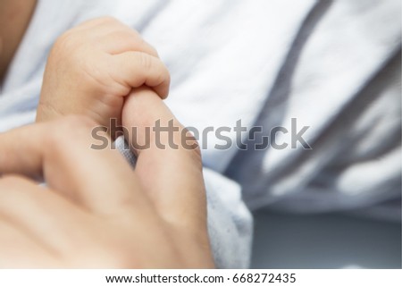 The mother is holding the hand of the baby . Mother's and baby's hands. Family concept