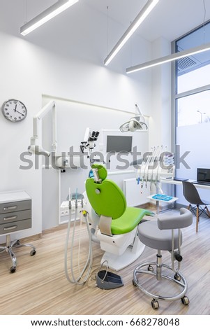 Dental treatment room with modern green chair 