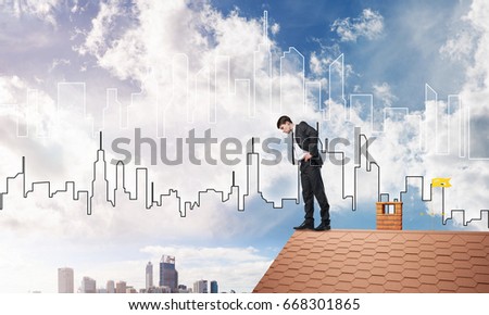 Young businessman standing on edge of house brick roof and looking down. Mixed media