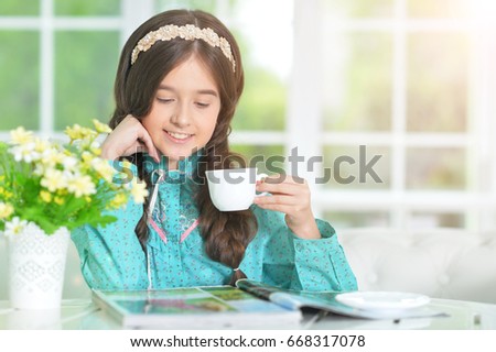 little cute girl reading magazine 