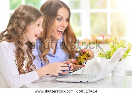 woman and  girl using laptop