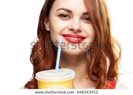 Beautiful young woman with red hair on white isolated background, soda, meal.