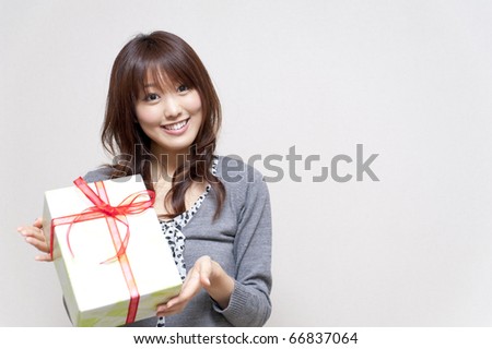 a portrait of beautiful girl holding a gift box isolated on white background