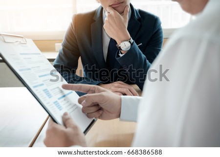 business man interviewer looking skeptical while listening to an asian female interview Royalty-Free Stock Photo #668386588