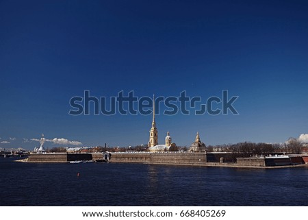 Peter and paul cathedral in St Petersburg against the blue sky. A large river with an island in the background of a beautiful sky with clouds and sun. Travel Russia.