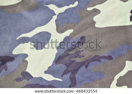 Texture of fabric with a camouflage painted in colors of the marsh. Army background image. Textile pattern of military camouflage fabric