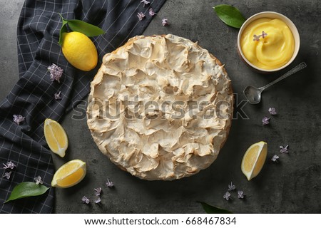 Composition with tasty lemon meringue pie on dark table