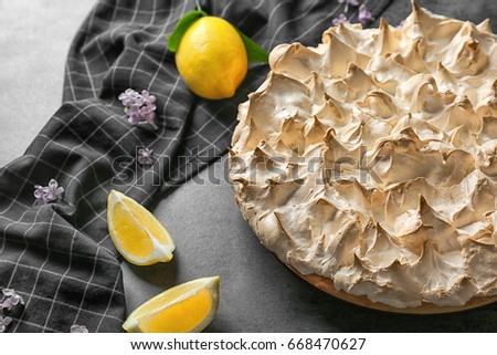 Tasty lemon meringue pie and napkin on dark table, closeup