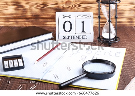 Handwritten alphabet in notebook with office stationery on brown wooden table