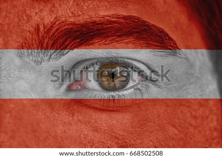 Human face and eye painted with flag of Austria