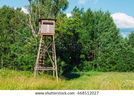 Wooden Hunter's stand in forest, wooden tower in summer time