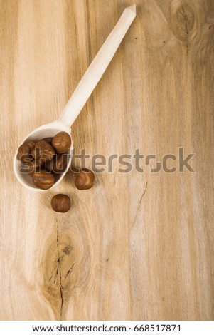 Almonds in a spoon on a wooden table close-up. Tasty and healthy nuts. Top view.