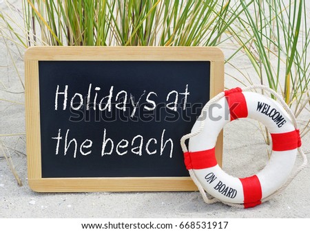 Holidays at the beach - welcome on board - chalkboard and lifebuoy with text