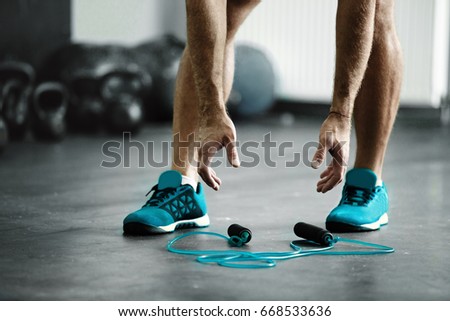 Young athlete man is ready for exercise with rope Royalty-Free Stock Photo #668533636