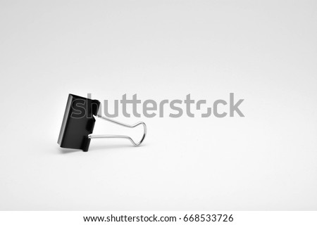 Black paper clip isolated on white background.
