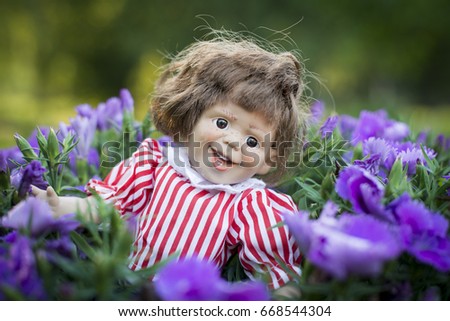 An expressive doll in flowers