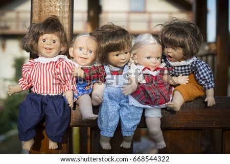 Five expressive dolls stand in a wooden box