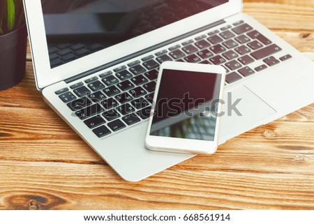 office desk with laptop smart phone and business office background.