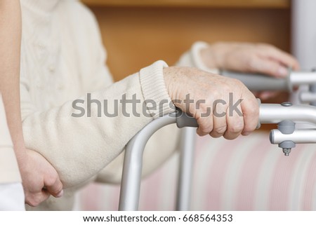 Disabled senior lady with her hands on a walker