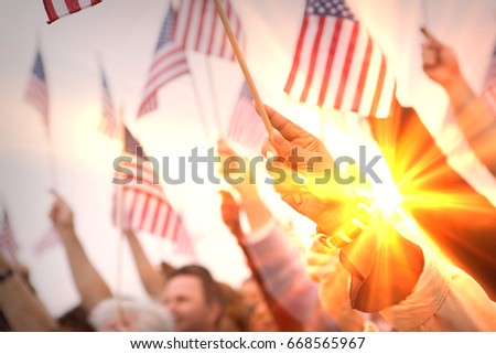 Crowd holding up American flags