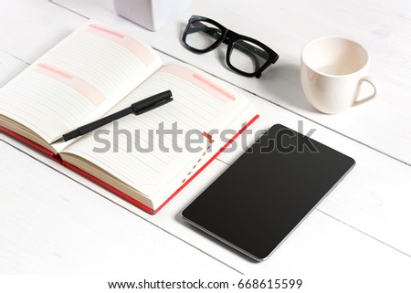 Stylish minimalistic workplace with tablet and notebook and glasses in flat lay style. White background.