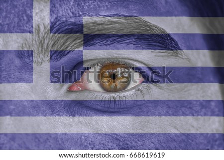 Human face and eye painted with flag of Greece