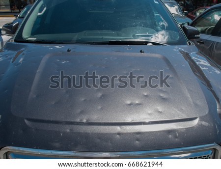 Dented car after a big hail storm Royalty-Free Stock Photo #668621944